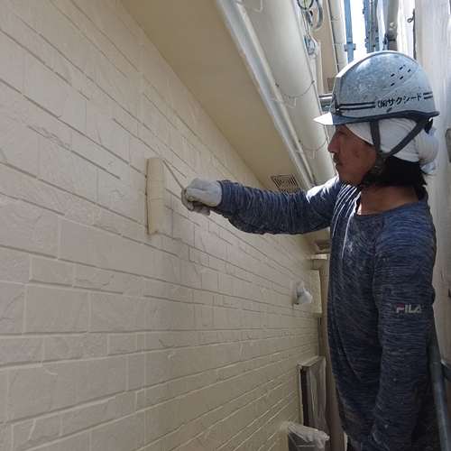 外壁の塗装をしている職人の写真