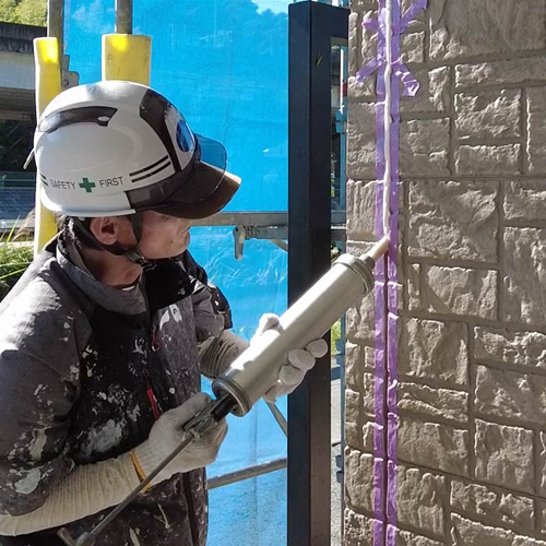 外壁目地にシーリングを充填している人の写真